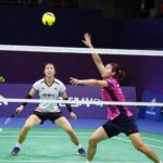 안세영 선수가 백핸드로 셔틀콕을 받아내는 순간 천위페이 선수가 네트 앞을 바라보고 있다