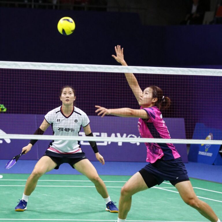 안세영 선수가 백핸드로 셔틀콕을 받아내는 순간 천위페이 선수가 네트 앞을 바라보고 있다