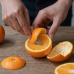 칼집을 낸 오렌지에 숟가락을 넣어 껍질을 분리하는 과정