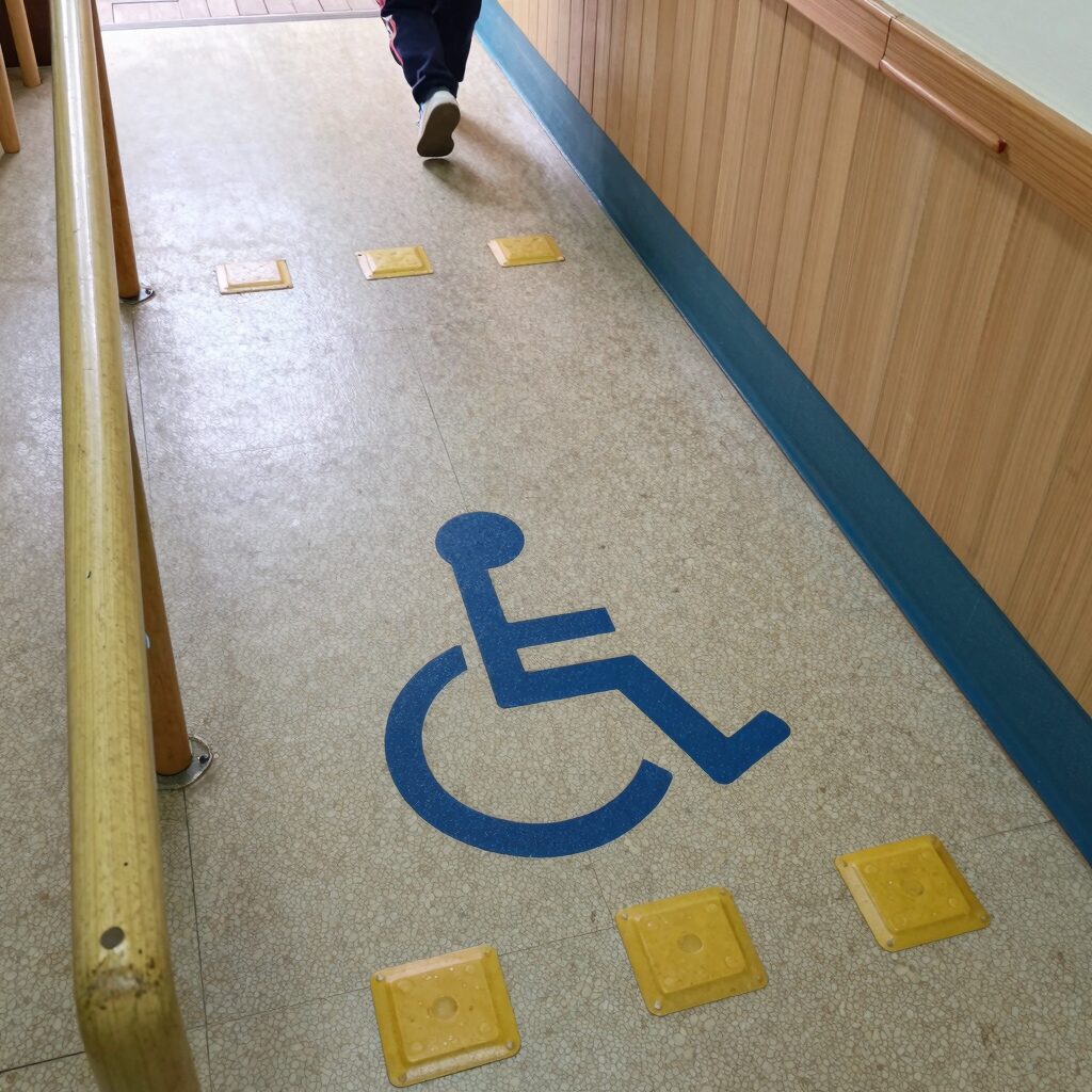 초등학교 복도에 설치된 장애인용 경사로와 점자 블록이 보이는 사진