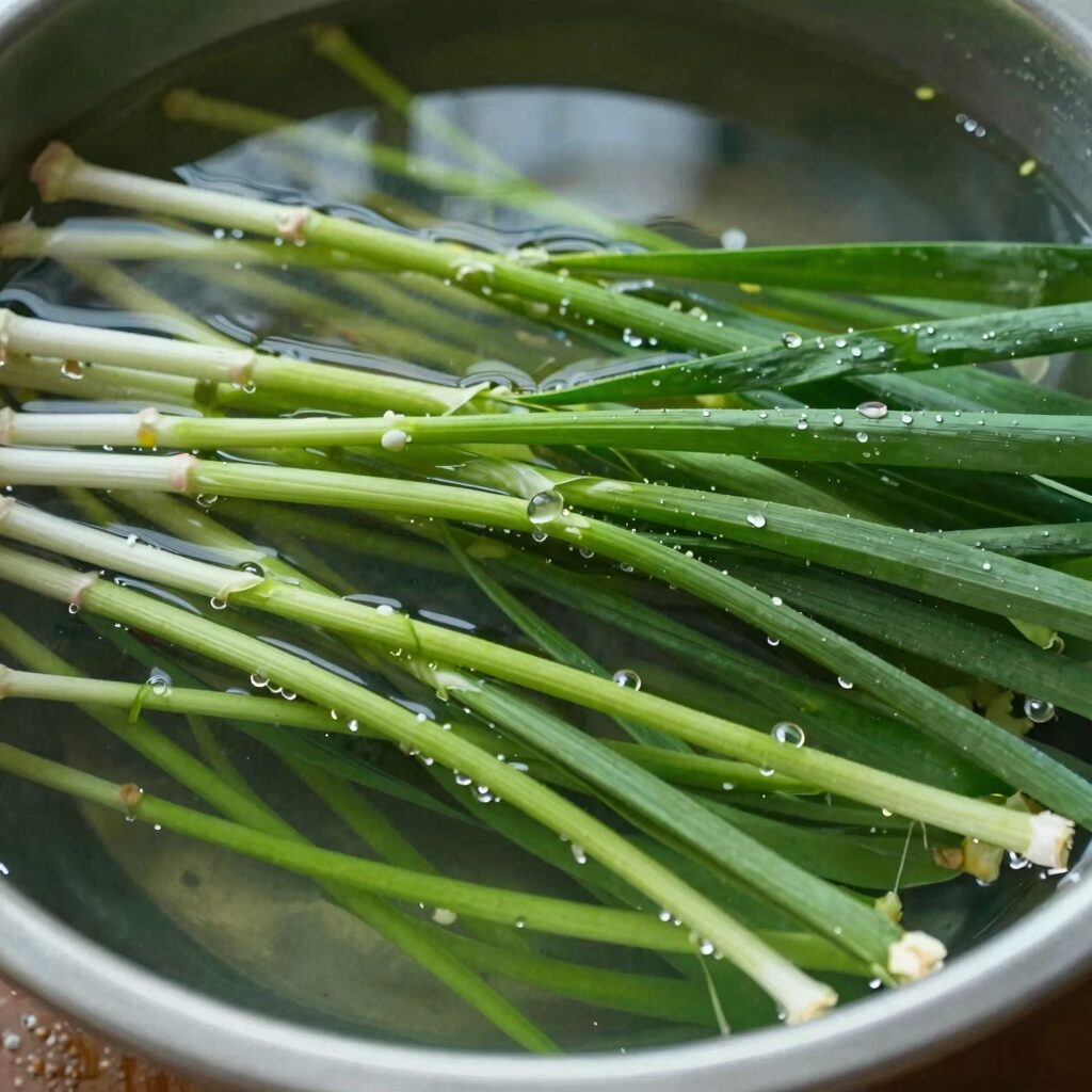 깨끗이 씻어 삶아낸 진한 초록색 쑥이 찬물에 담겨 있는 모습