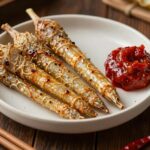 데친 참두릅이 접시에 담겨 있고 옆에 초고추장이 놓여 있는 모습