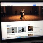 이상댄스 웹사이트 메인 화면과 춤시장 게시판 목록이 보이는 모니터 화면