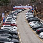 강화 고려산 진달래축제 임시 주차장 전경, 많은 차량이 주차되어 있고 산으로 가는 길이 보인다