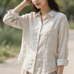 햇살이 따사로운 봄날, 올젠 린넨 블렌드 셔츠를 입고 야외에서 포즈를 취한 여성의 모습. 차분한 컬러의 셔츠가 자연스러운 분위기를 연출한다.