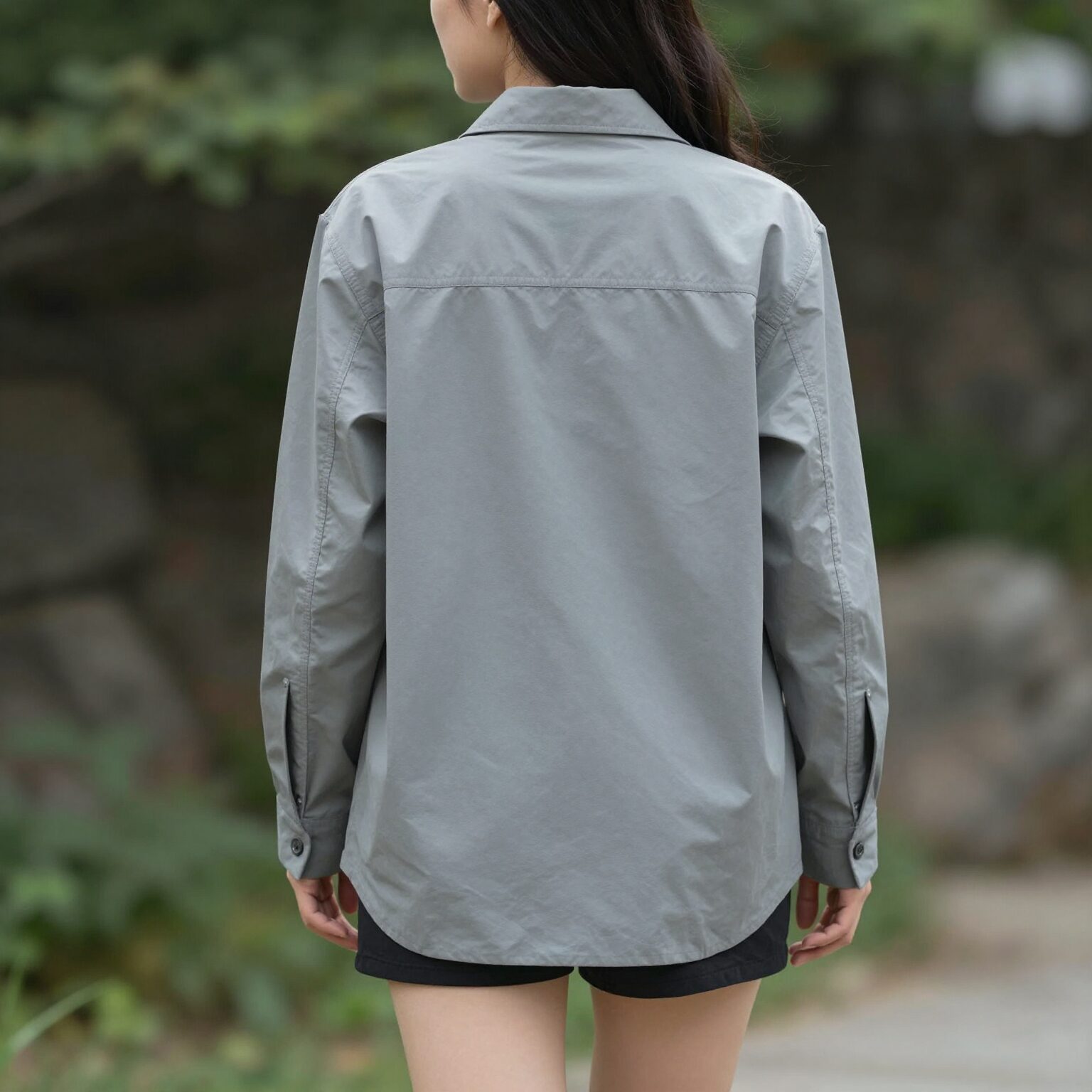 반팔 티셔츠 위에 오버핏 셔츠를 걸쳐 입은 여성의 뒷모습