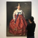 페르난도 보테로 전시 포스터 앞에서 찍은 사진으로 풍만한 인물과 화려한 색감이 돋보임