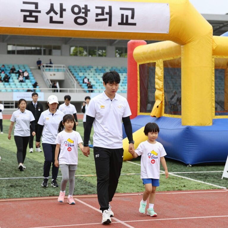 군산대학교 대운동장 어린이날 행사 현장 사진. 가족 마라톤 출발선과 에어바운스 부스가 보인다.